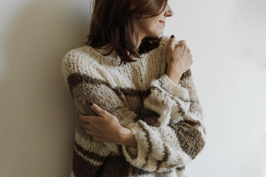 smiling woman giving herself a hug