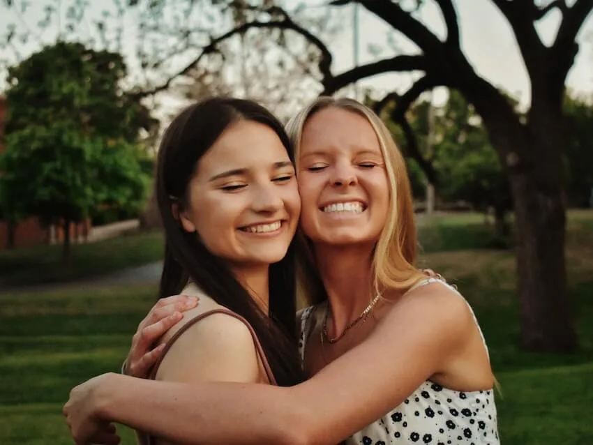 two smiling women hugging