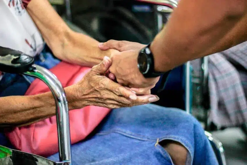 woman holding an elderly woman's hands