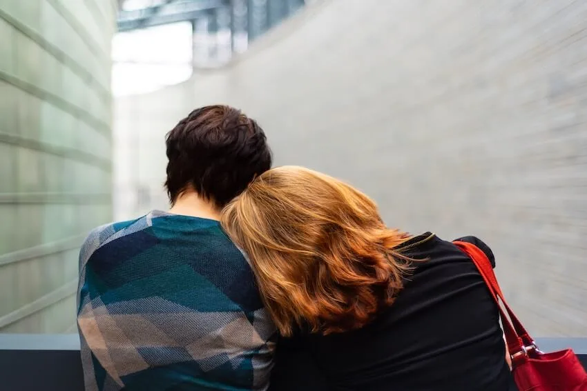 woman leaning on her friend's shoulder